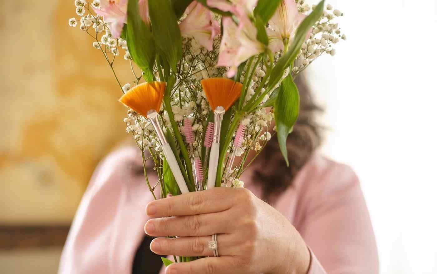 Fan brushes and fresh flowers held by Melinda